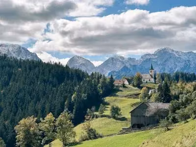 Green alpine valley under snowy peaks